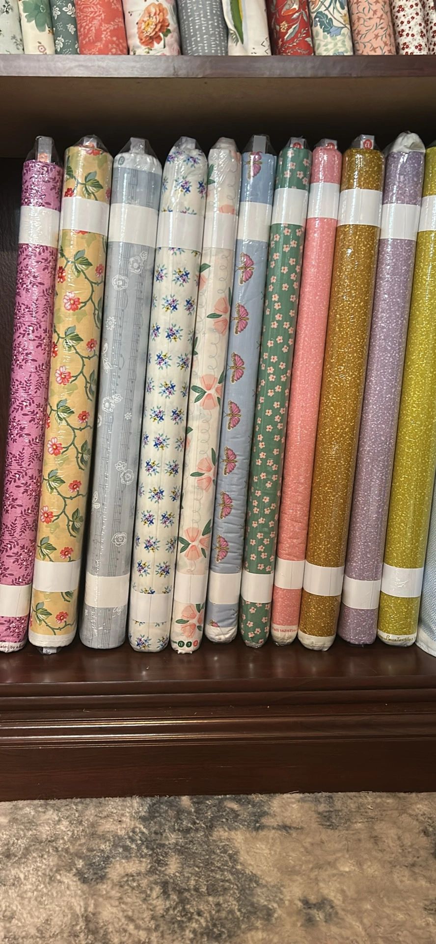 Colorful fabric rolls stacked on wooden shelves